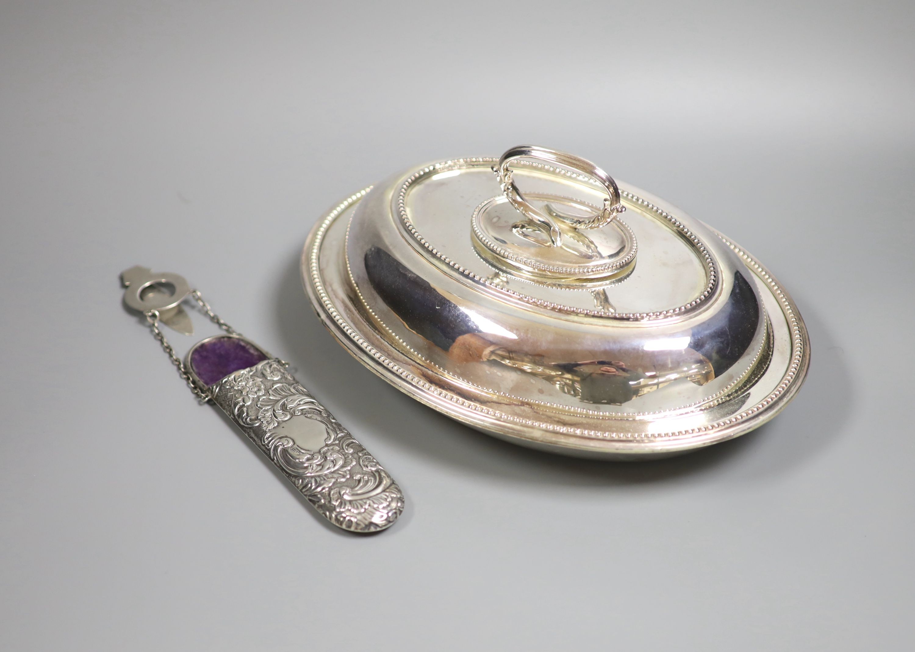 An Edwardian repousse silver scissors case, Birmingham, 1905, 16.4cm and a plated entree dish and cover.